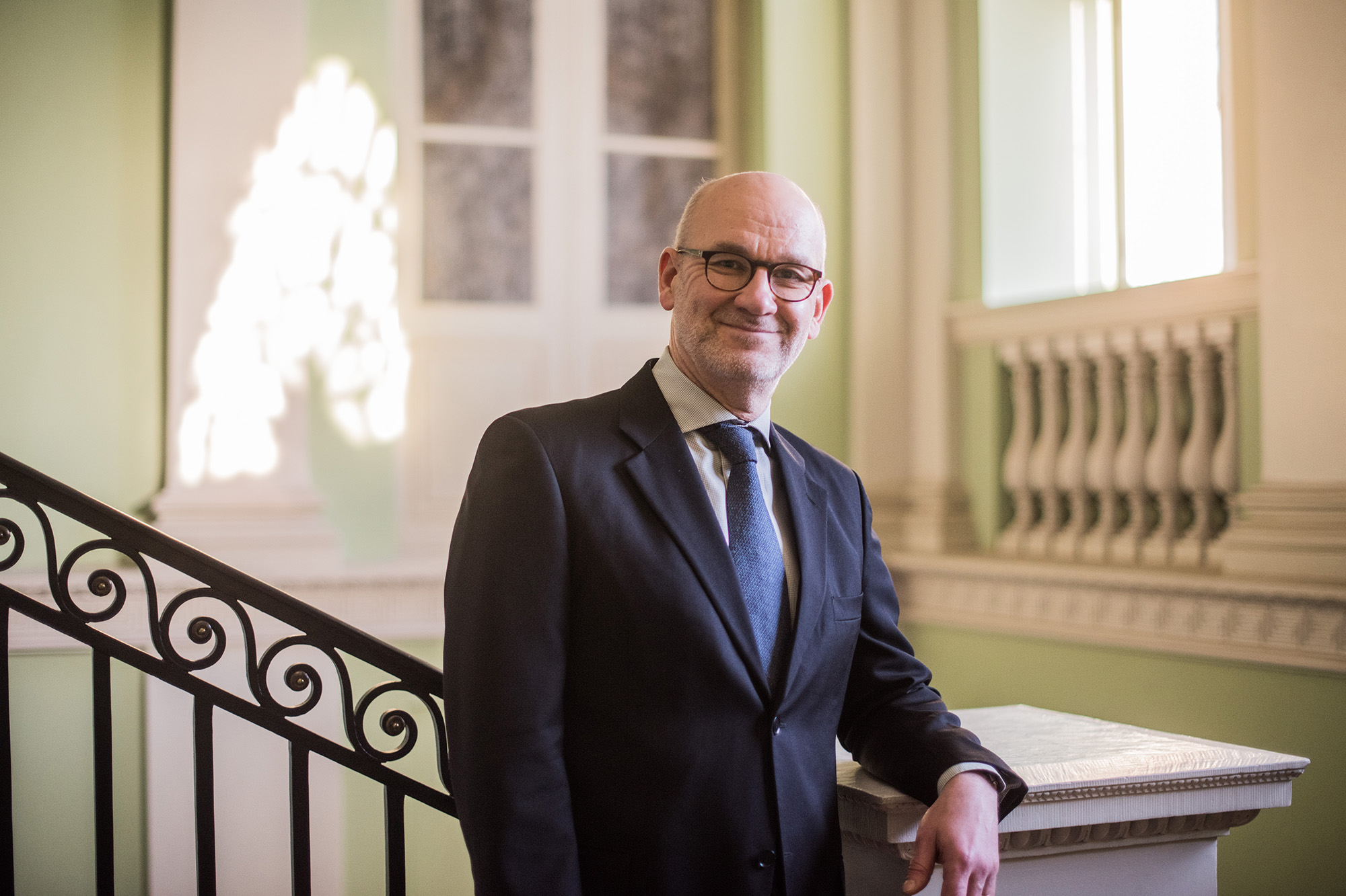 Deputy Chancellor of Justice Mikko Puumalainen smiling and wearing a suit in the Government Palace.